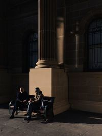 Full length of woman sitting on railing