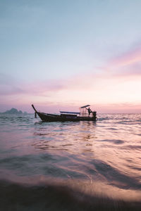 Silhouette boat in sea against sky during sunset