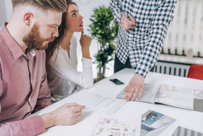 Young couple discussing over document while real estate agent explaining 