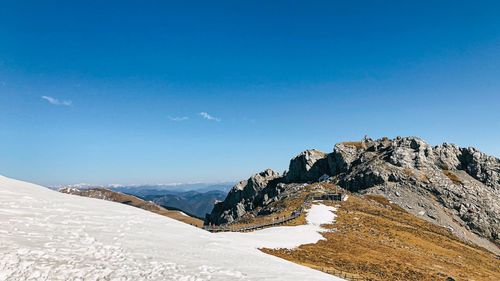 Scenic view of snowcapped mountain against blue sky