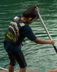 Rear view of boy standing in lake