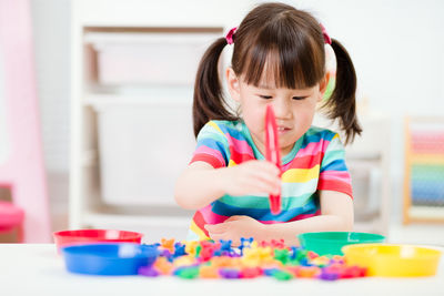 Young girl play math and color sorting fine motor skill game for homeschooling