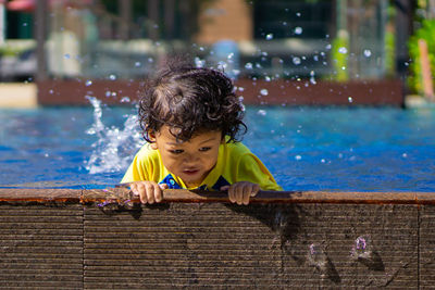 Boy looking away while swimming in pool