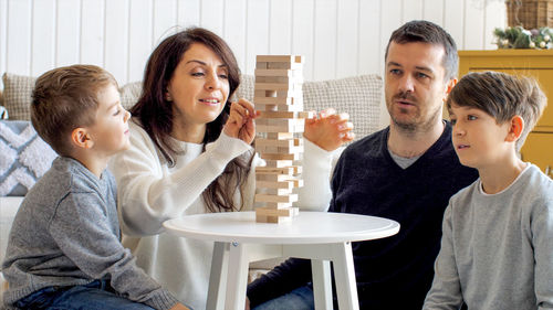 Happy friends sitting on table