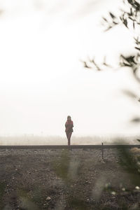 Woman standing on field against sky