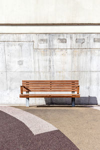 Empty bench against wall