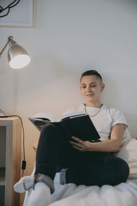 Young woman reading in bed