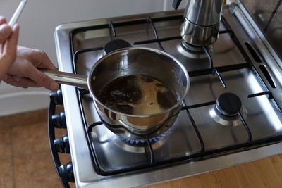 Midsection of person preparing food in kitchen at home