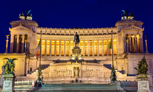 Statue in city at night