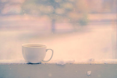 Close-up of coffee on table against sky during winter