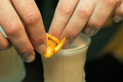 Cropped hand of bartender making cocktail
