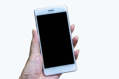 Low section of person holding smart phone over white background