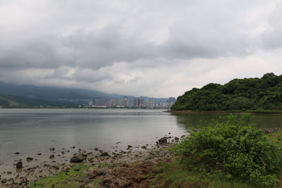 Scenic view of river against cloudy sky