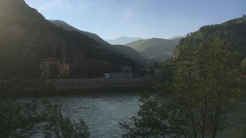 Scenic view of river by mountains against sky