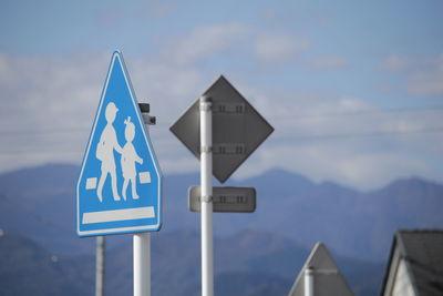 Close-up of road sign against sky