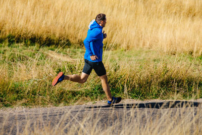 Full length of boy running on field