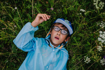 High angle portrait of boy lying on land
