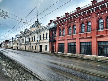 Cars on city street against sky