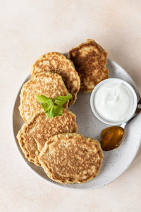 Tasty oatmeal pancakes served with jam and natural yogurt on ceramic plate,