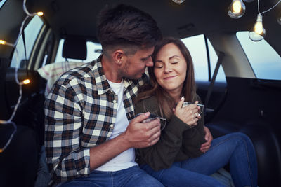 Couple having coffee in car