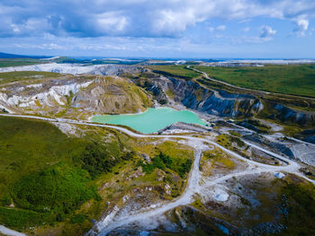 Aerial view of landscape against sky, including blue-green body of water