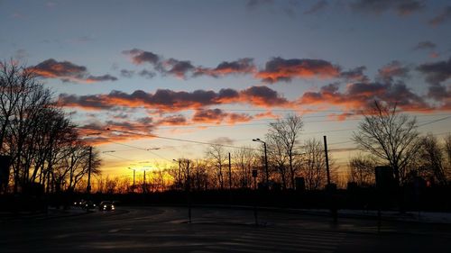 Silhouette trees on landscape against sky during sunset