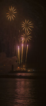 Firework display over river at night