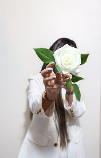 Midsection of woman with roses against white background