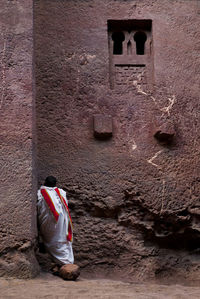 Rear view of man standing by old building