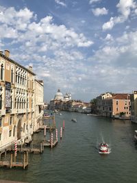 Boats in canal amidst buildings in city