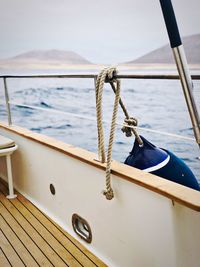 Close-up of rope tied to railing against sea