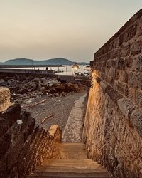 Footpath by sea against sky