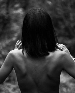 Rear view of shirtless woman standing outdoors