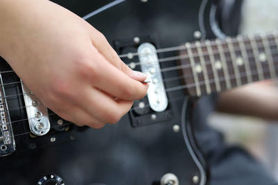 Midsection of man playing guitar