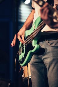 Midsection of man playing guitar