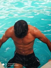 Rear view of shirtless man in swimming pool