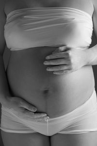 Close-up of pregnant woman with hands on stomach