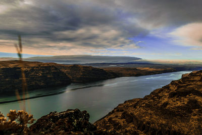 Scenic view of sea and mountains against sky