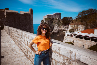 Rear view of woman standing against old building