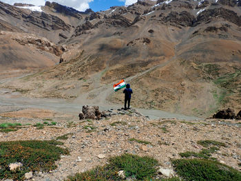 Full length of person on arid landscape against mountains