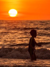 Full length of man standing on beach during sunset