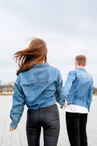 Rear view of friends standing against the sky