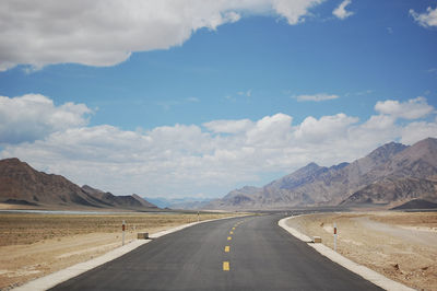 A flat newly built unmanned asphalt road leads to the front