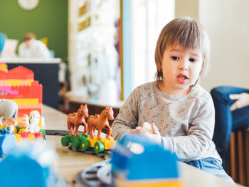 Toddler plays with toy blocks. little boy stares on toy constructor. kindergarten or nursery. 