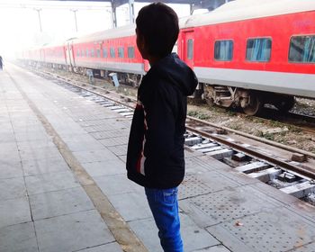 Rear view of man standing on railroad station platform