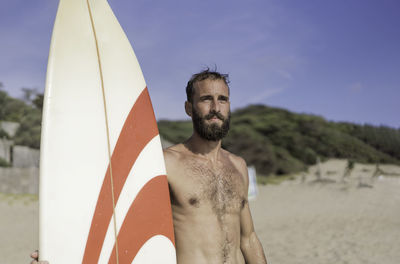 Midsection of shirtless man standing on beach