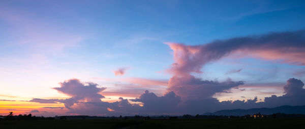 Scenic view of silhouette field against sky at sunset