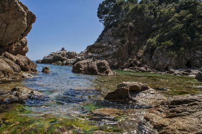 Rock formations by sea against sky