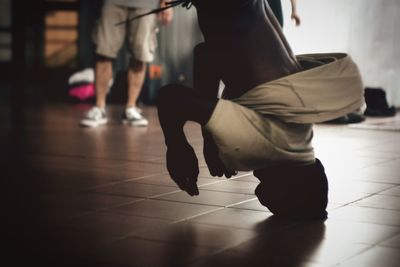 Low section of woman dancing on tiled floor