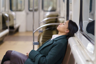 Returning home late. sleeping african businesswoman in empty subway underground wagon at night